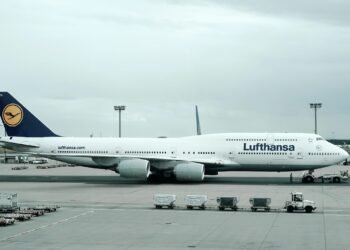 Frustrierte Passagiere betrachten die Anzeigetafel mit aktuellen Flugstreichungen